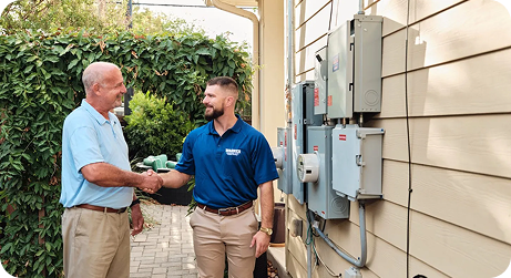 tech shaking mans hand in yard of home